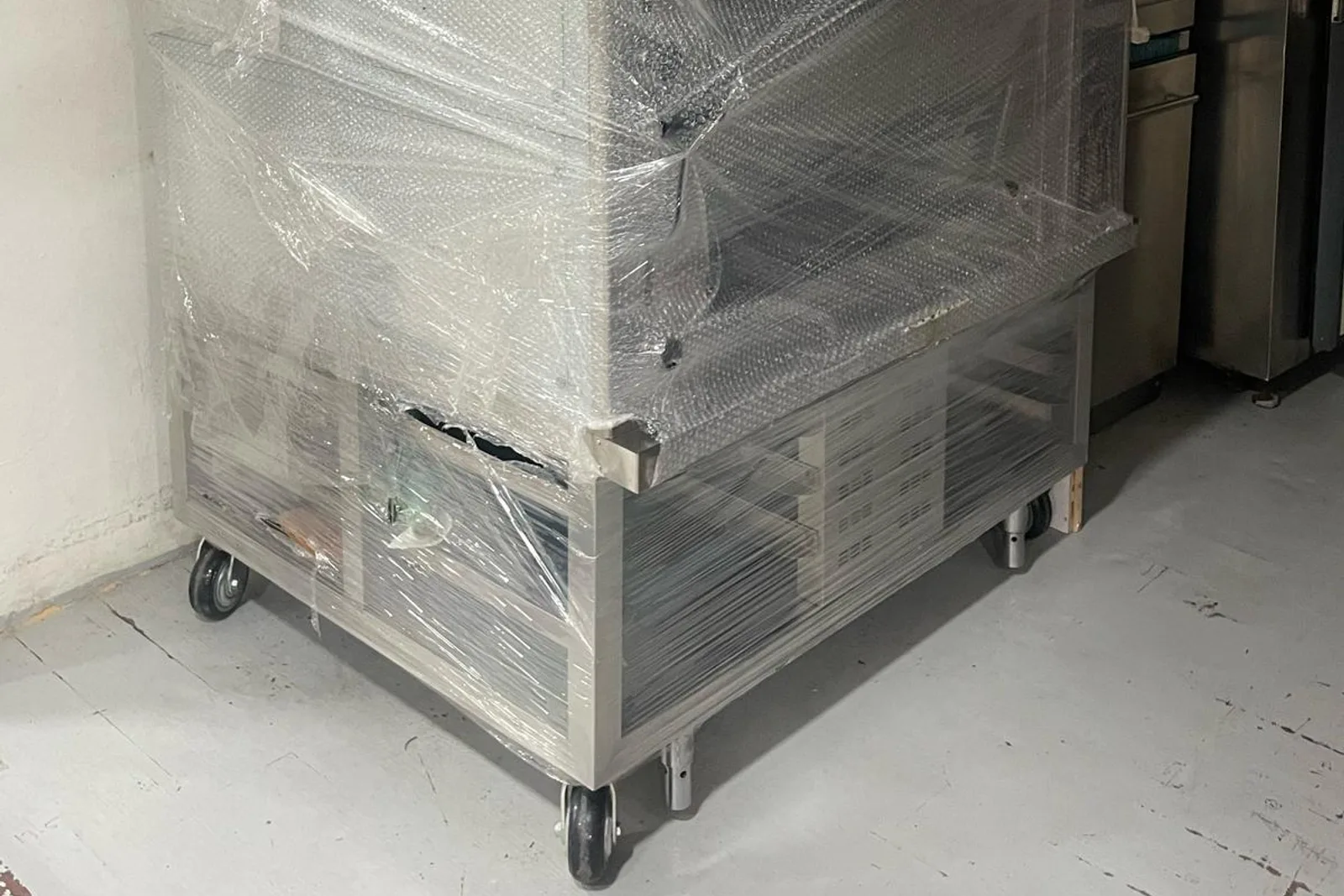 Wrapped commercial equipment protected and secured for transport